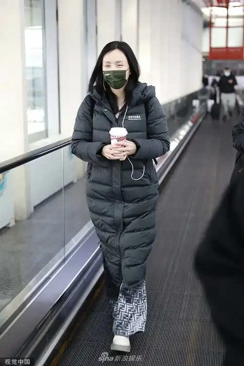组图陶虹穿长款学院羽绒服时尚又温暖手推行李边走边发语音
