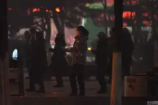 沈阳雾霾笼罩广场舞大妈戴口罩坚持跳舞
