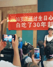 搞笑gif图美女30岁生日,家人拉了横幅写了几个字,美女害羞了
