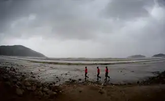 舟山朱家尖海边的滞留游客准备撤离到安全地带

